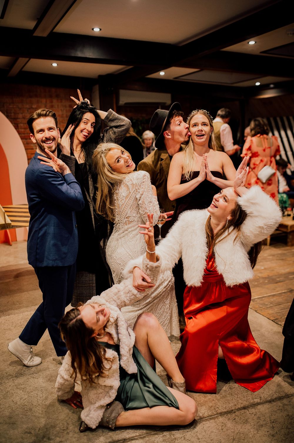 Wedding guests dancing and having fun at a lively reception party with dramatic dips and spins on the dance floor.