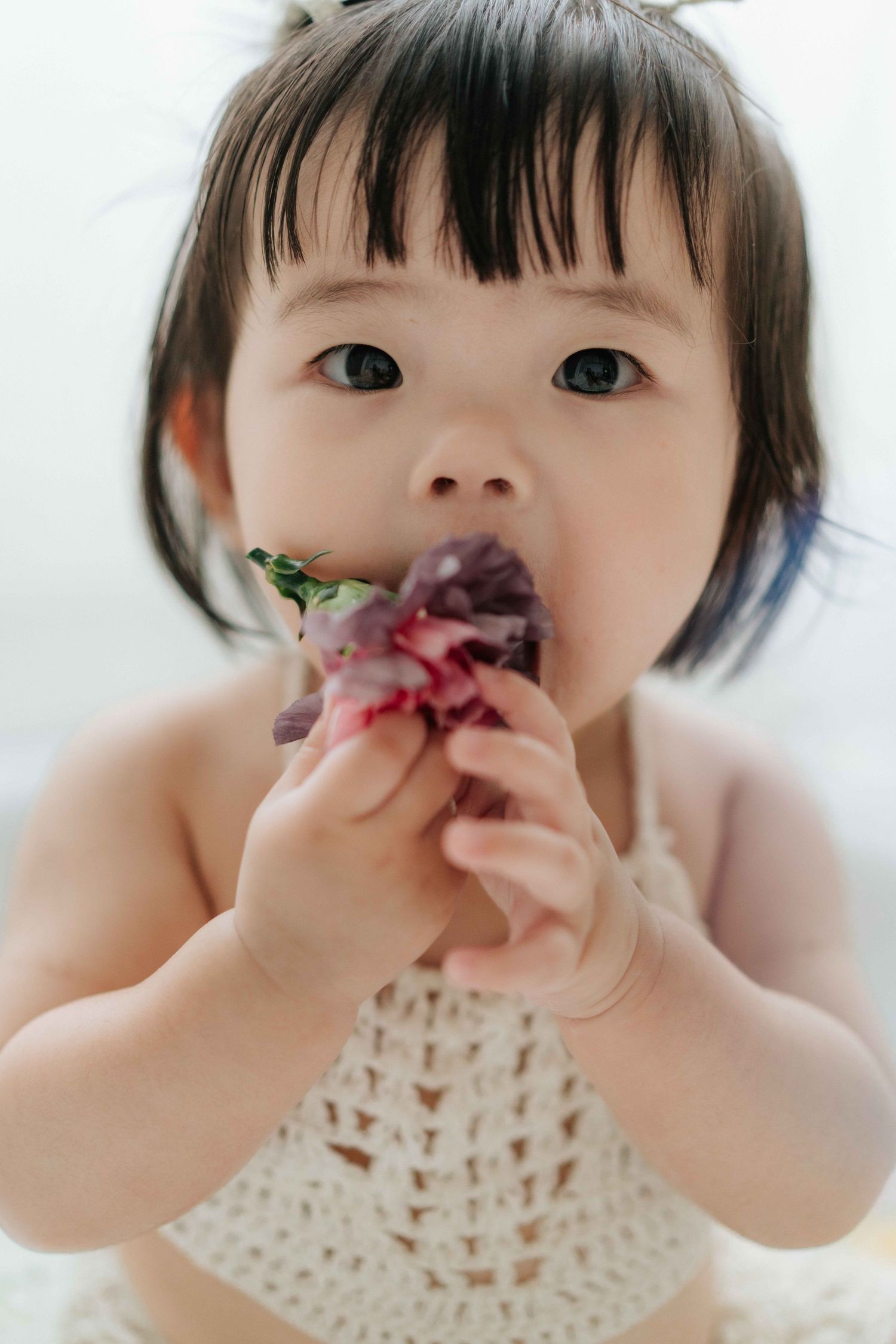 Series of cake smash photos with white dress, teddy bears, balloons and orange backdrop for baby milestone celebration.
