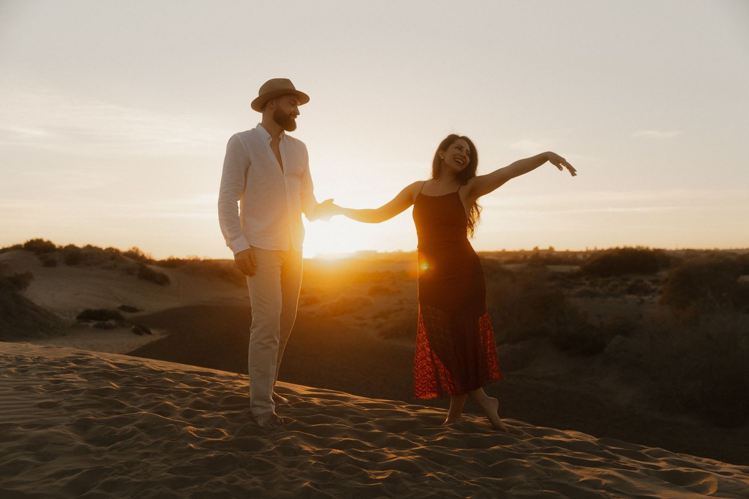 Stylish couple posing on a desert ridge, professional destination wedding photographer.