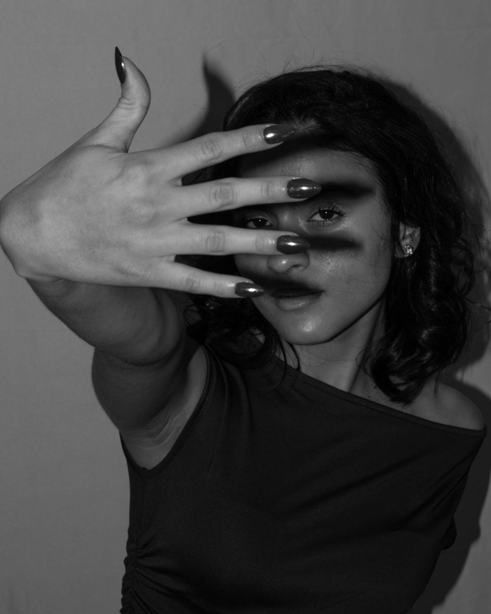 Black and white artistic portrait series showing a person in shadow covering their face with their hand in dramatic poses.