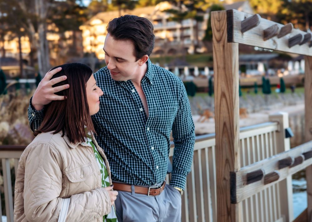 Couple walking toward dock with flowers before proposal at Ritz-Carlton Lake Oconee
