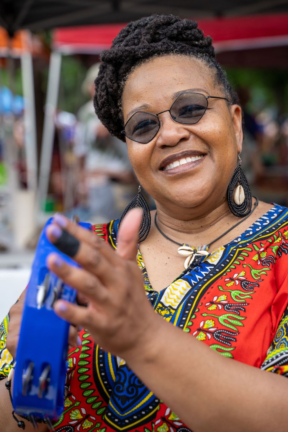 Close-up sequence showing colorful African print clothing and blue mobile phone in hands.