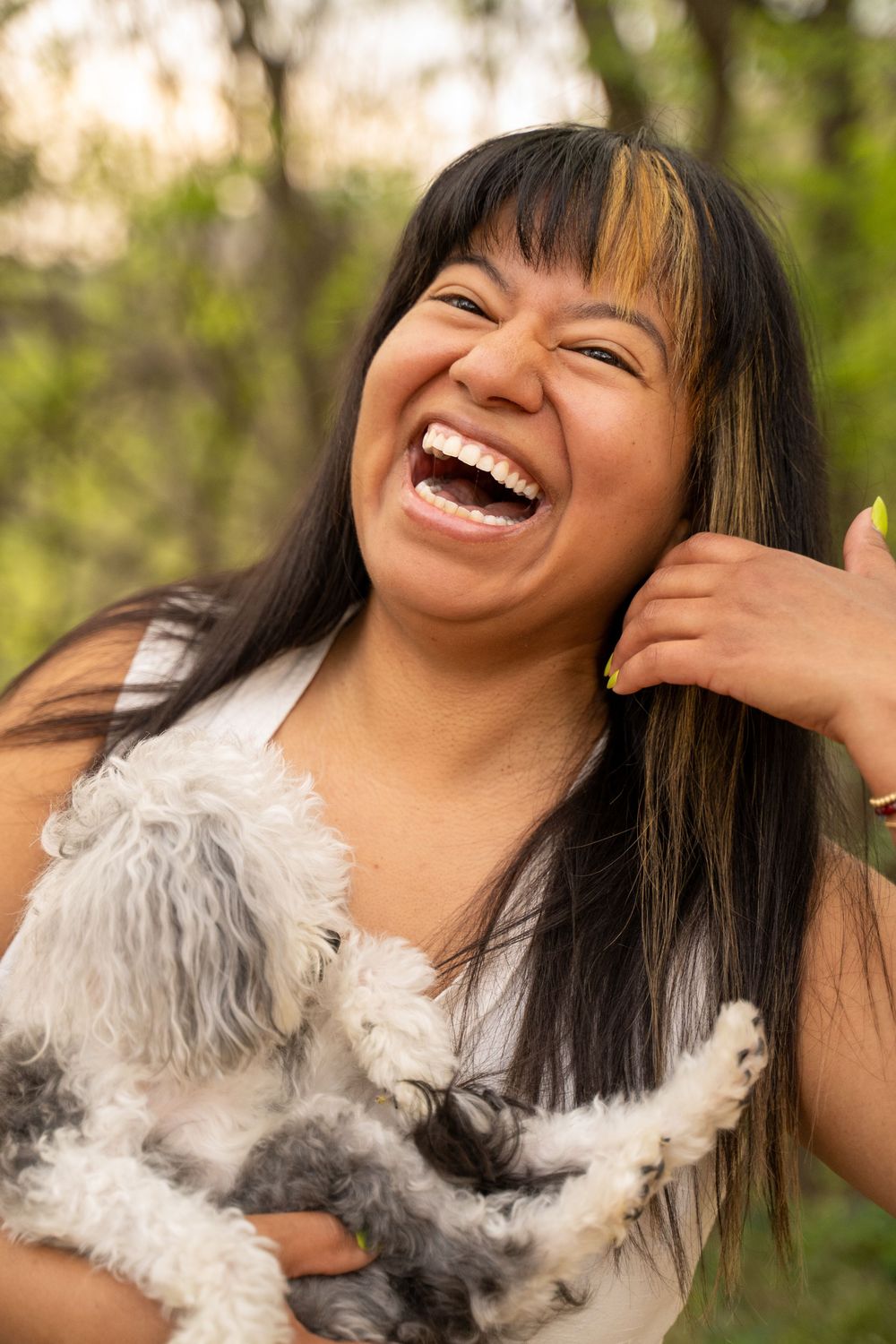 A series of joyful portraits showing genuine laughter while cuddling with a fluffy white dog outdoors.