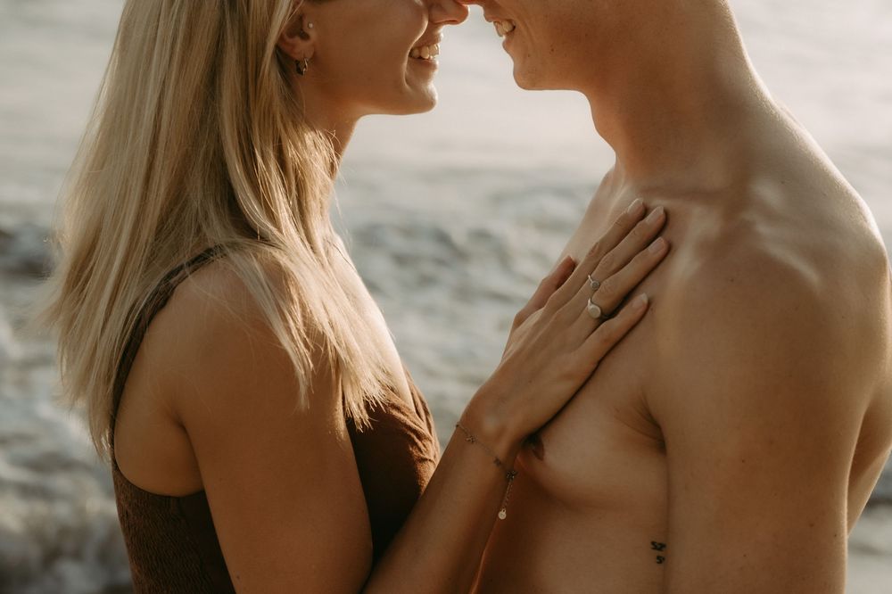 Intimate couple embracing in soft natural lighting during romantic outdoor photoshoot.