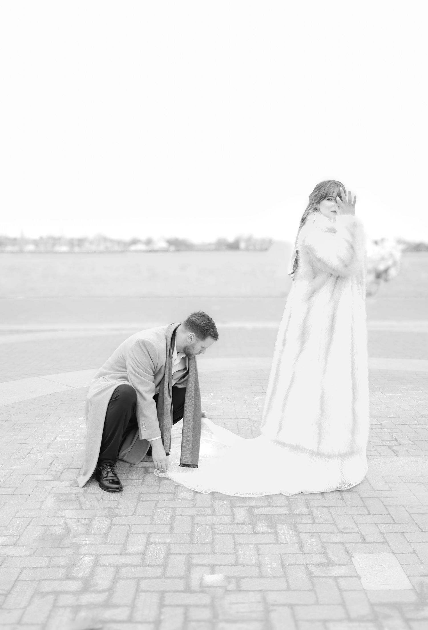Black and white photo of couple in formal wear on brick patio with dramatic poses.