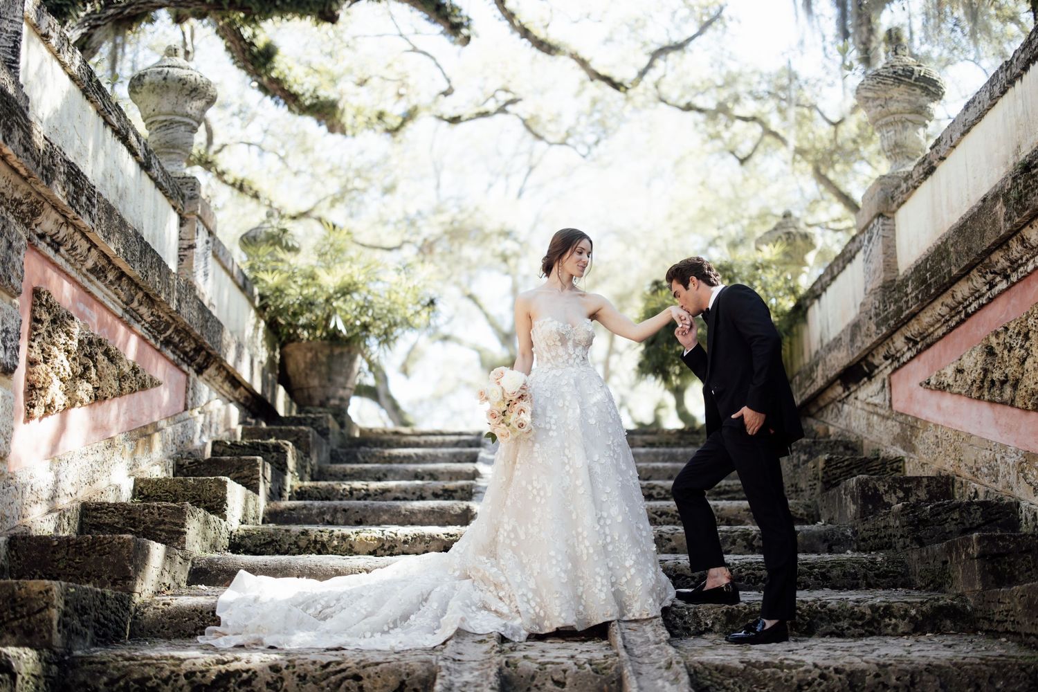Wedding photos taken on rustic stone steps under Spanish moss draped trees in a romantic garden setting.