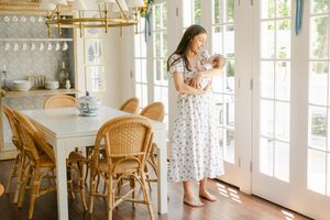 Bright sunlit room with French doors, wicker furniture, and white decor in a coastal style.