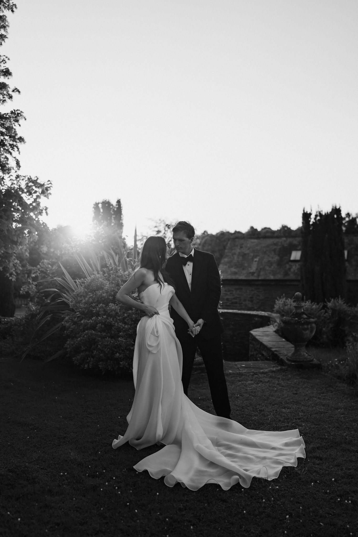 groom holding bride during an intimate moment in the setting sun at dewsall court in herefordshire
