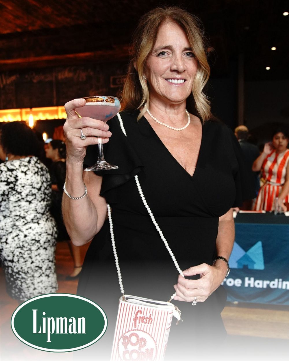 Guest enjoying a cocktail at an evening event with Lipman branding.