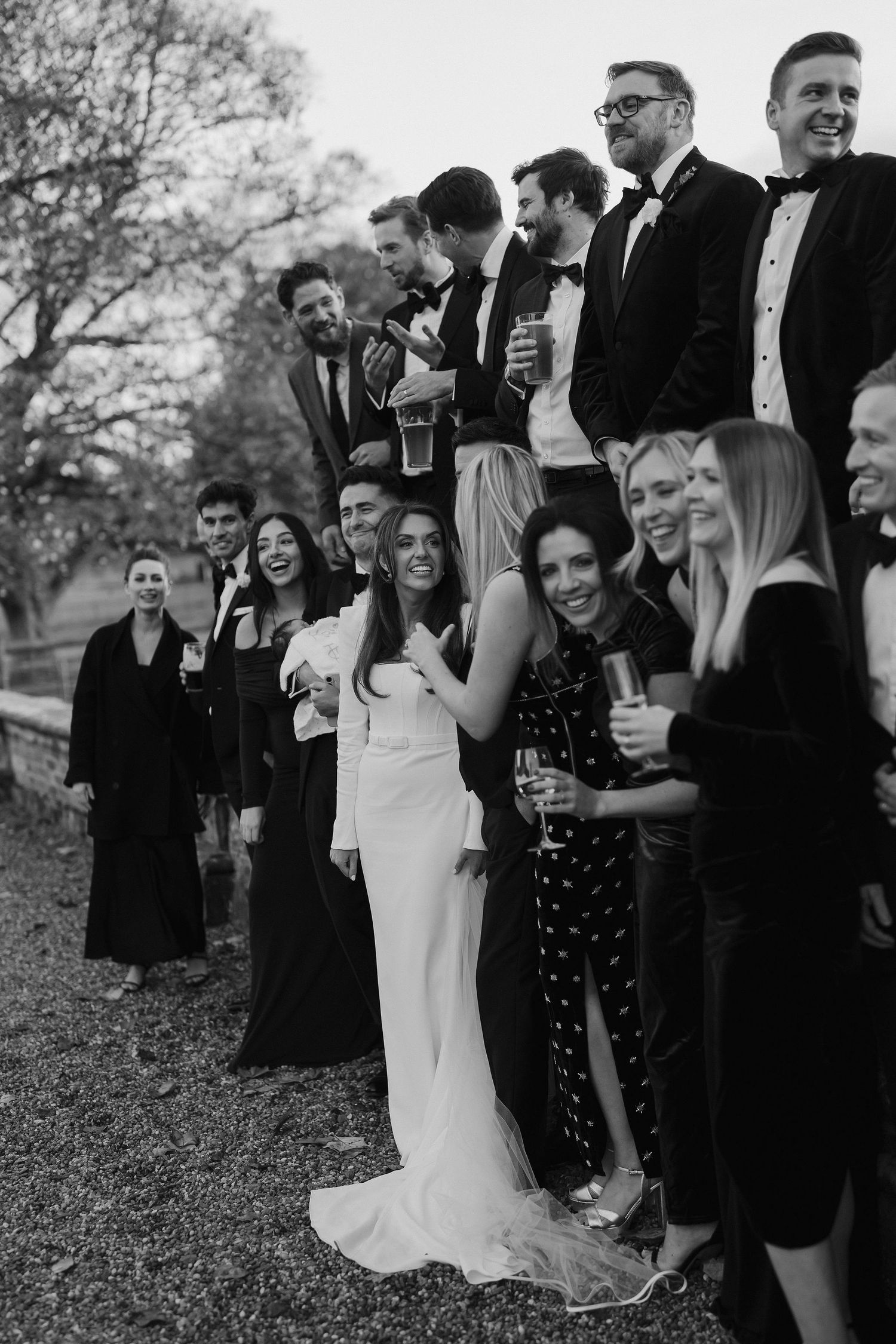 bride and groom talking and laughing with friends outside Iscoyd park