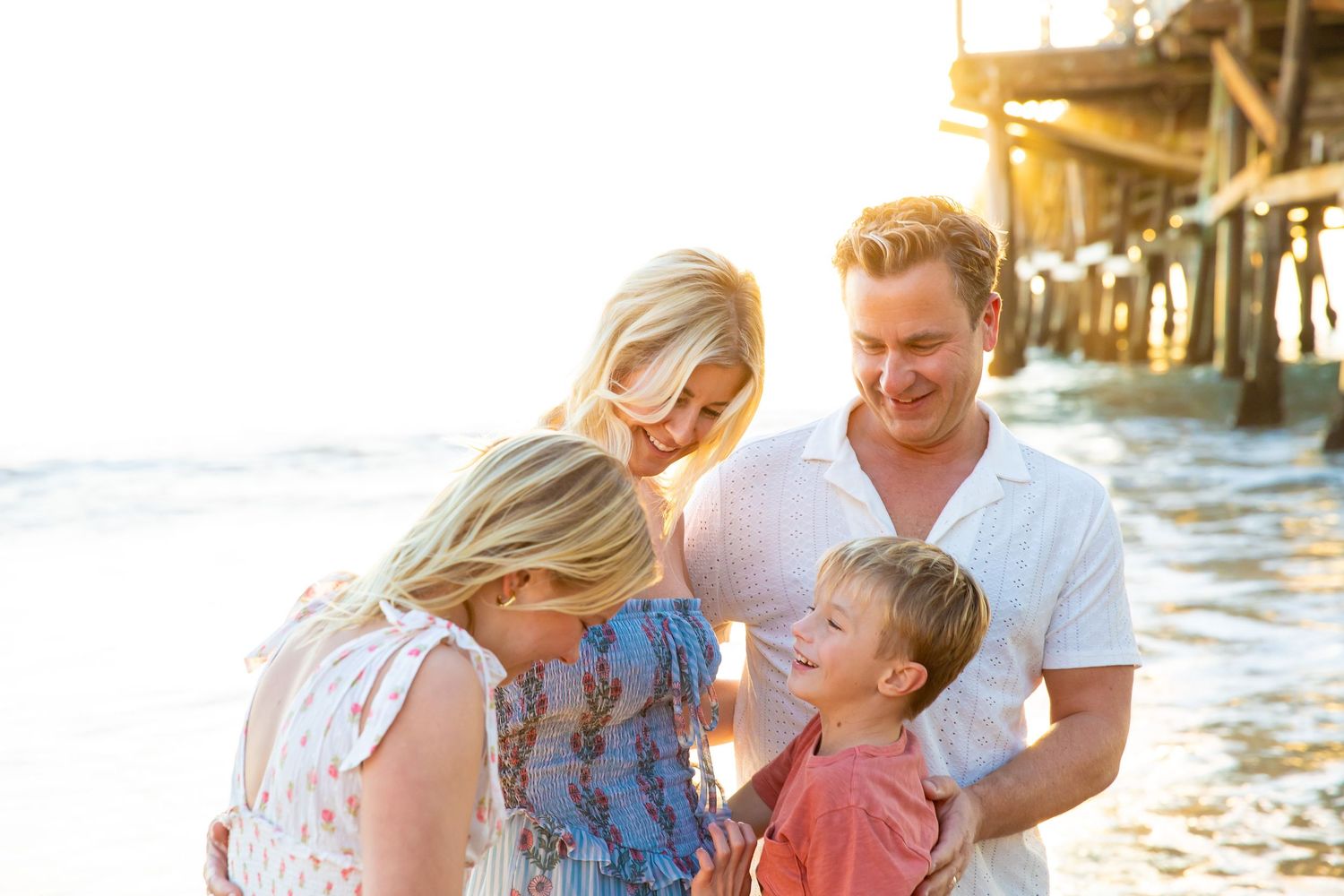 A happy family shares joyful moments together on a sunny beach at sunset.