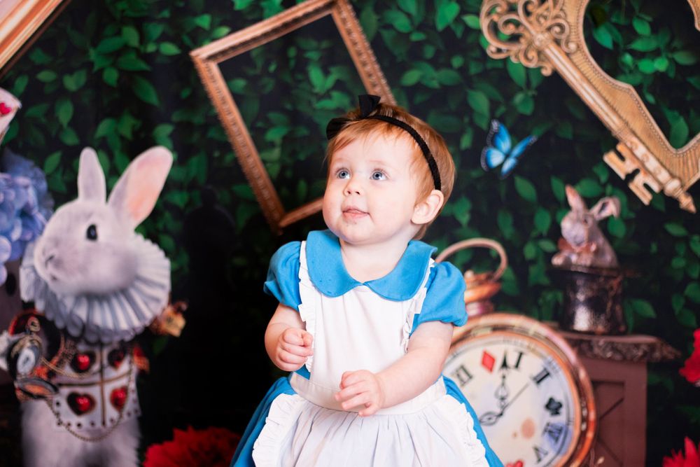A series of four photos showing a baby in blue and white clothing with Easter bunny decorations and spring scenery.