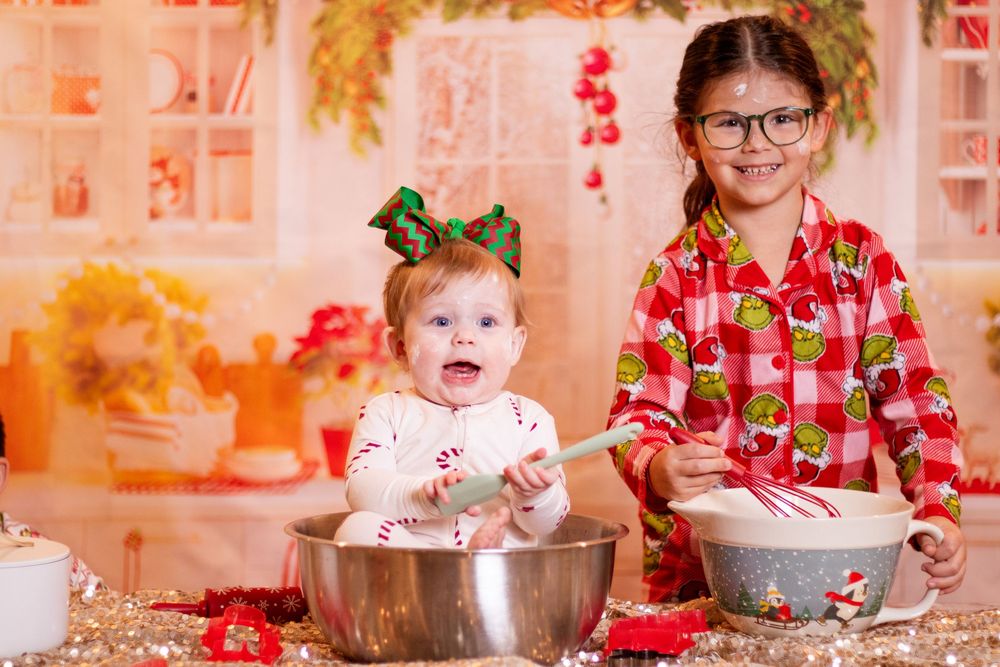Children in festive attire mix ingredients in a kitchen while baking holiday treats together.