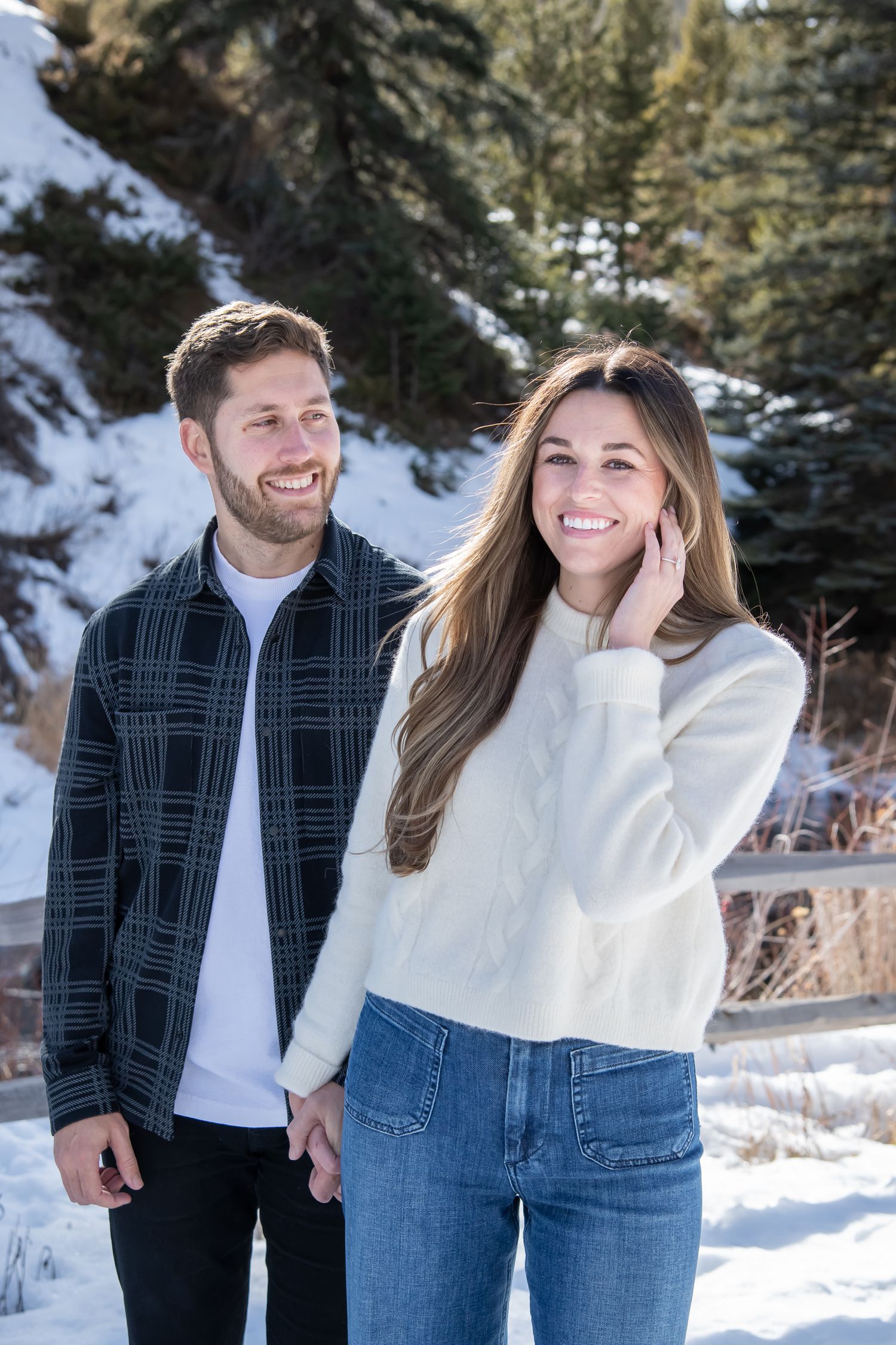 Cute and candid moment of a couple walking together in the snow during a winter engagement photo session in Vail Colorado