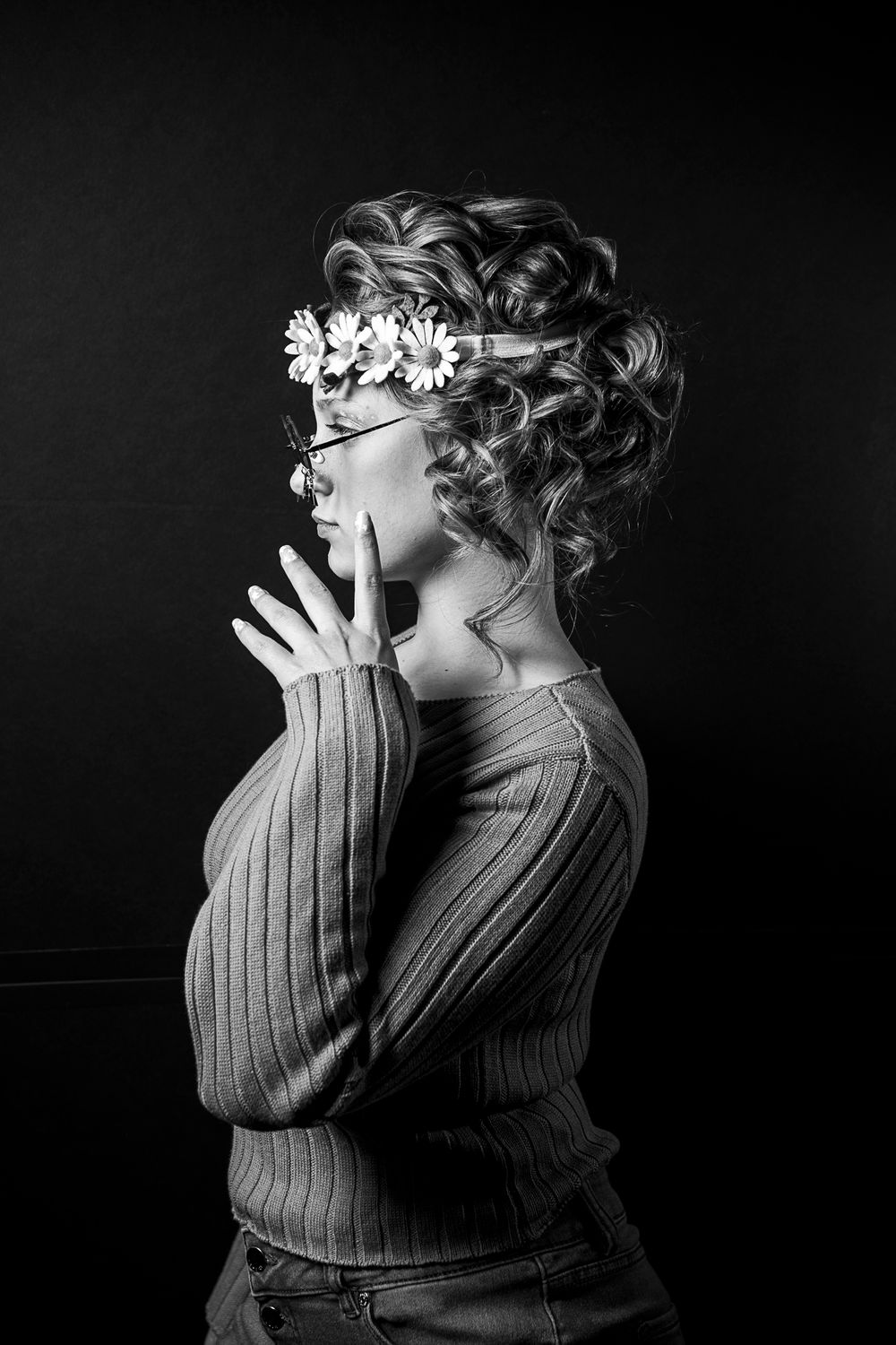Artistic black and white side profile with floral crown and ribbed sweater.