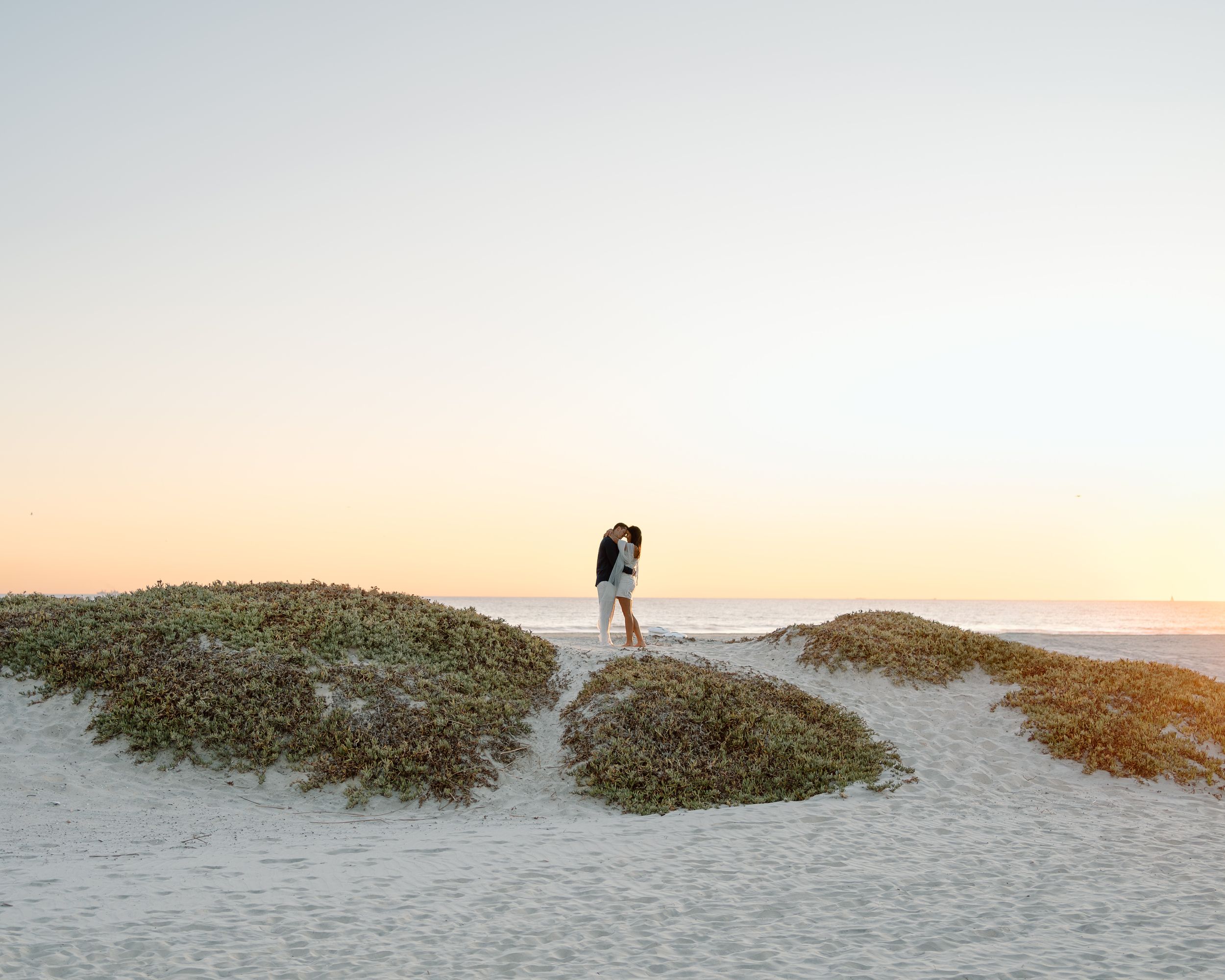 Dreamy engagement session at a scenic beach in San Diego. Silhouette photography capturing romance, adventure, and golden hour serenity.