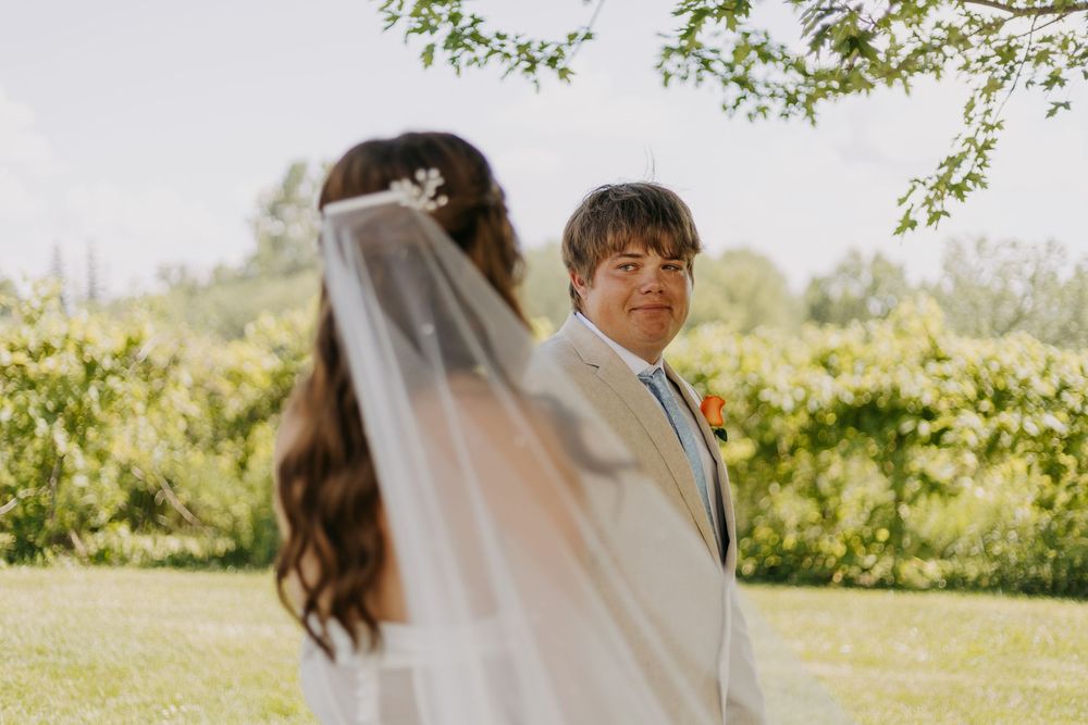 A bride and groom share an intimate moment in a sunlit garden during their wedding celebration.