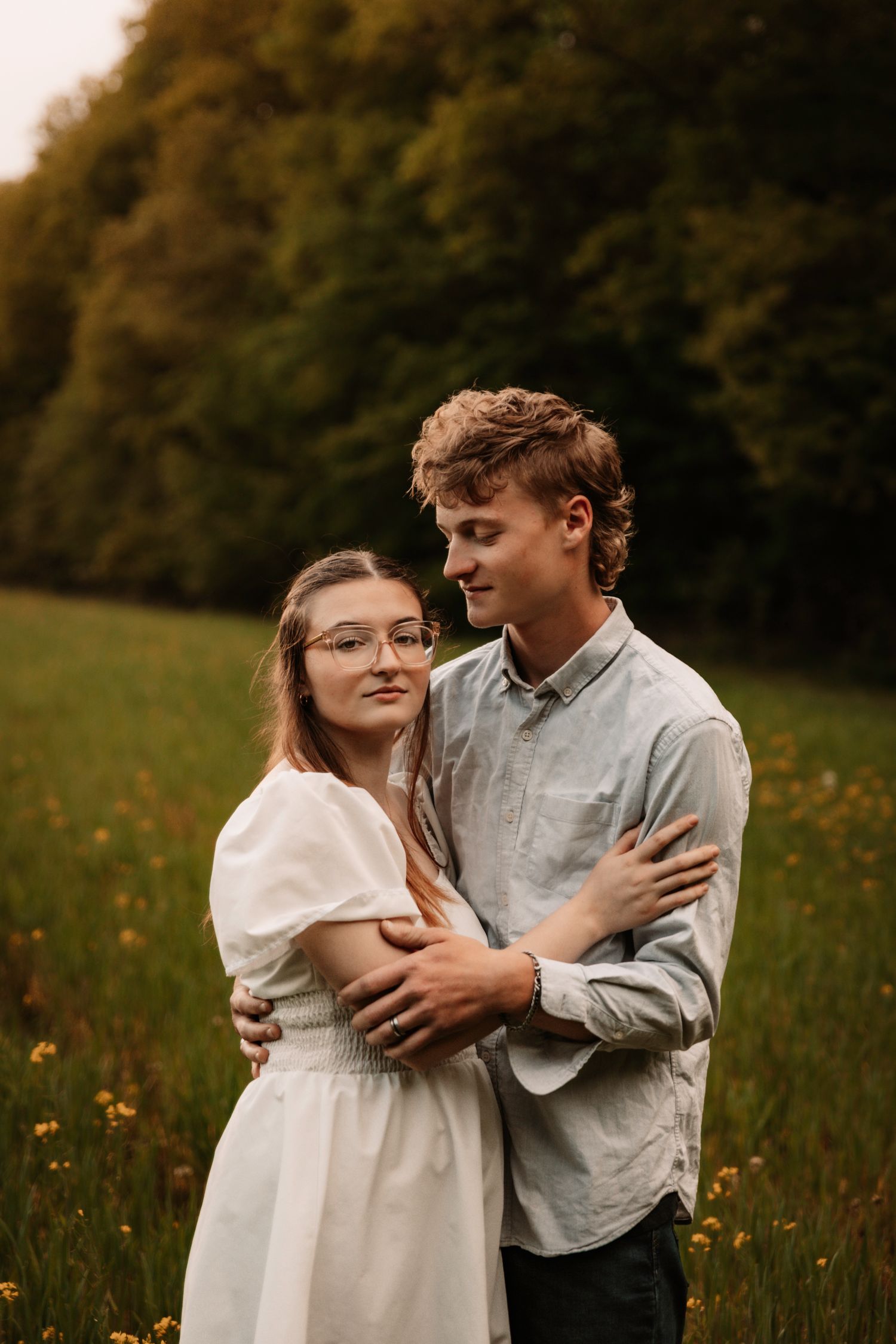 A couple laughs together during a sunset photoshoot in their backyard.