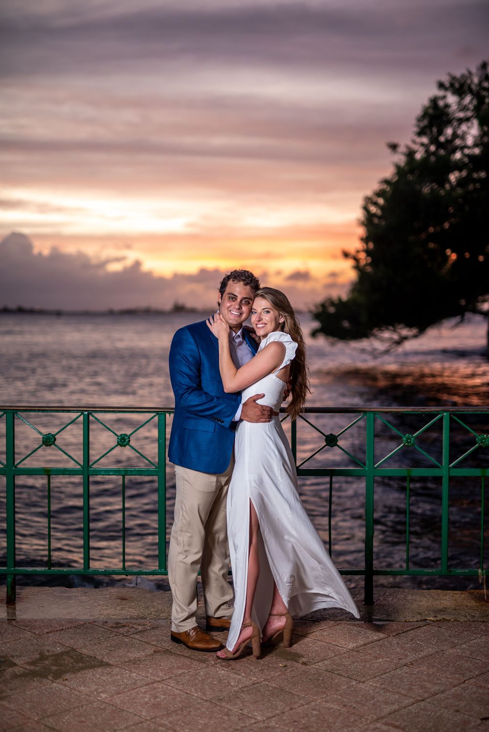 A stunning sunset portrait by the ocean with dramatic pink and purple sky.