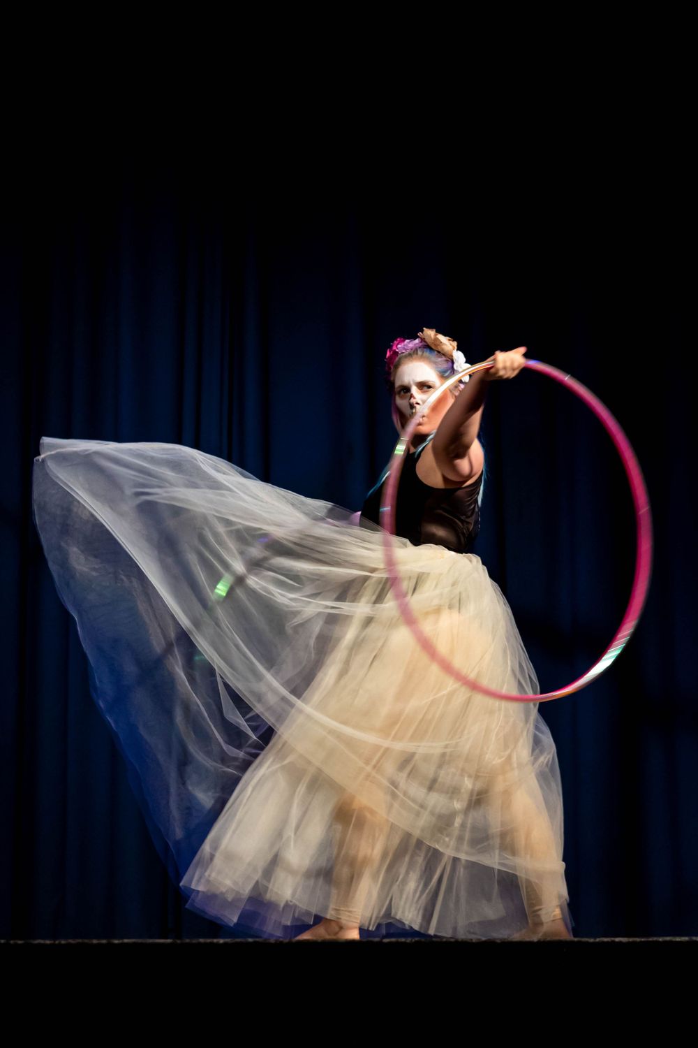 event photography Brighton of a Circus performer using a hoop onstage she wears a net skirt and halloween make up