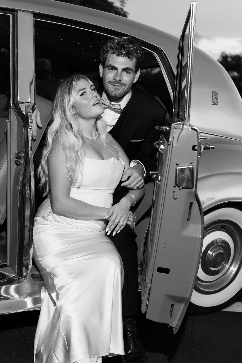 Bride and groom embracing with glowing Hard Rock Guitar Hotel in the night sky background, romantic South Florida wedding portrait