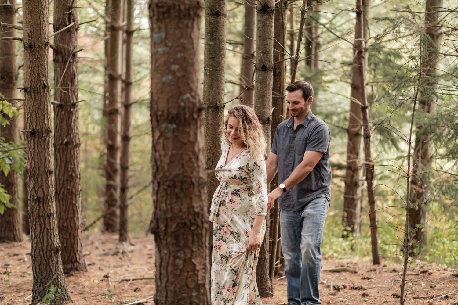 Maternity couple walks through the woods at Cataraqui Creek in Kingston, Ontario.