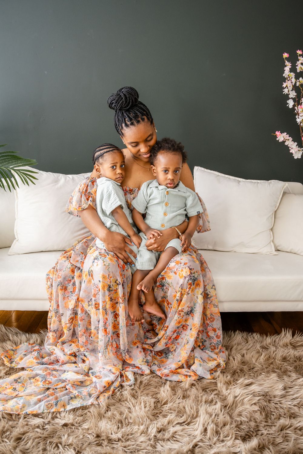 Family portrait on white sofa showing loving embraces in matching outfits.