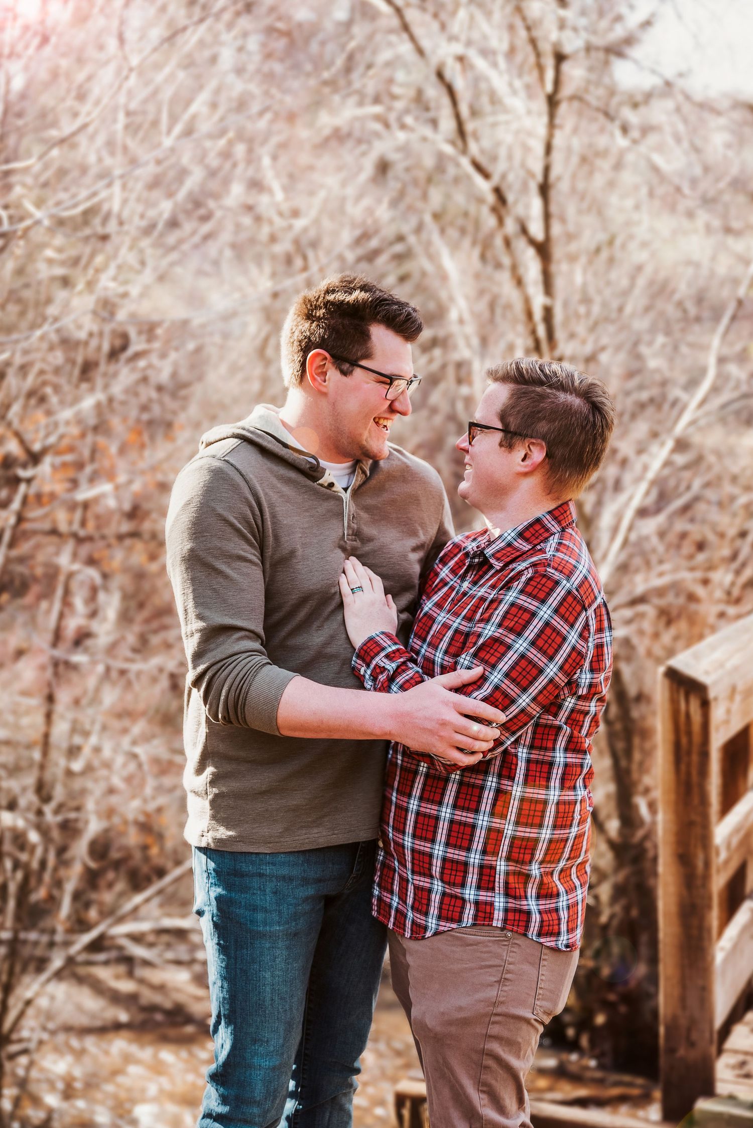 LGBT couple in front of bridge at Gibson Jack Trail in Pocatello, Idaho showing off wedding ring.