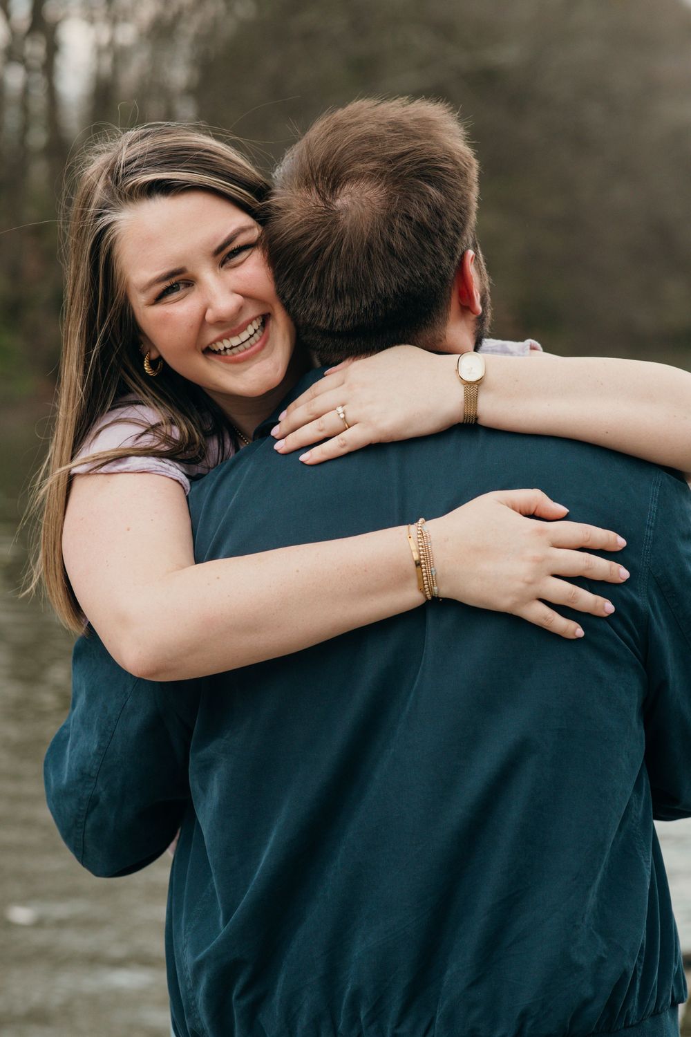 Engagement photo capturing her excitement as she wraps her arms around him showing off the ring.