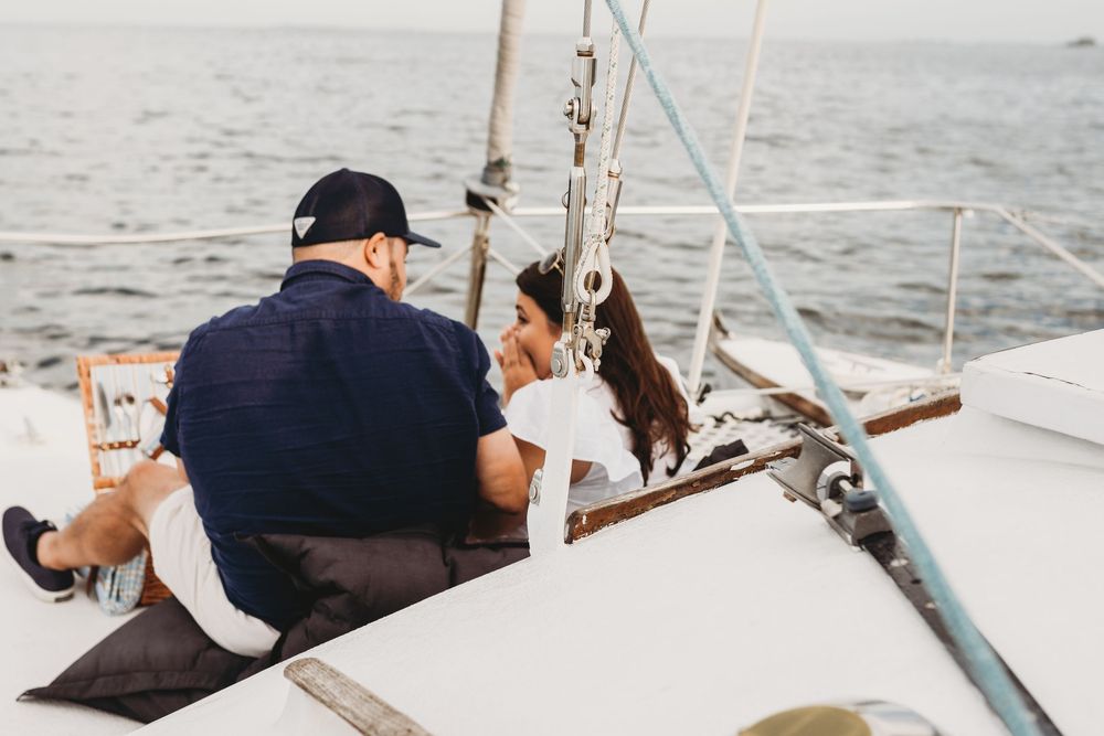 Surprise proposal on a boat near Honeymoon Island Florida with emotional reaction and ocean backdrop