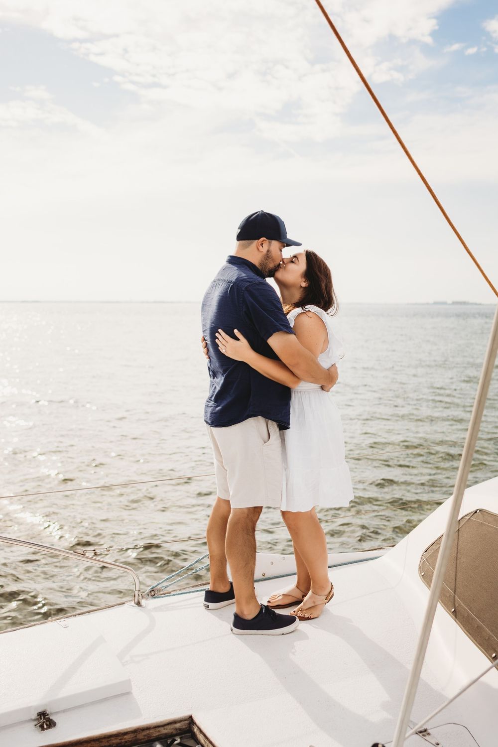 Newly engaged couple kissing on a boat after a surprise proposal near Honeymoon Island