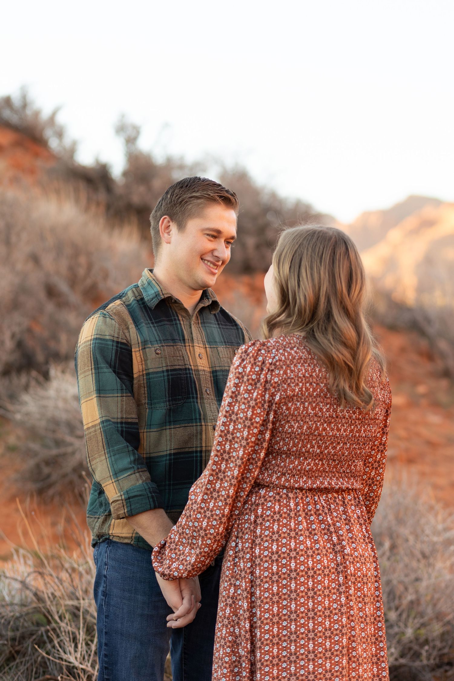 man and woman holding hands looking at each other