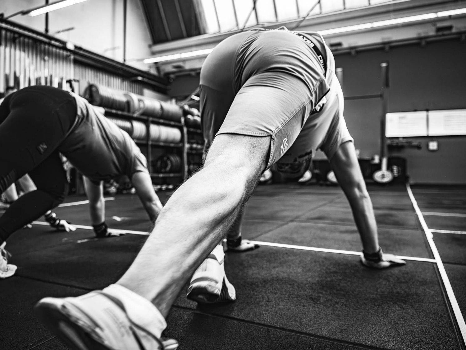 Athletes performing stretching exercises in a modern gym facility.