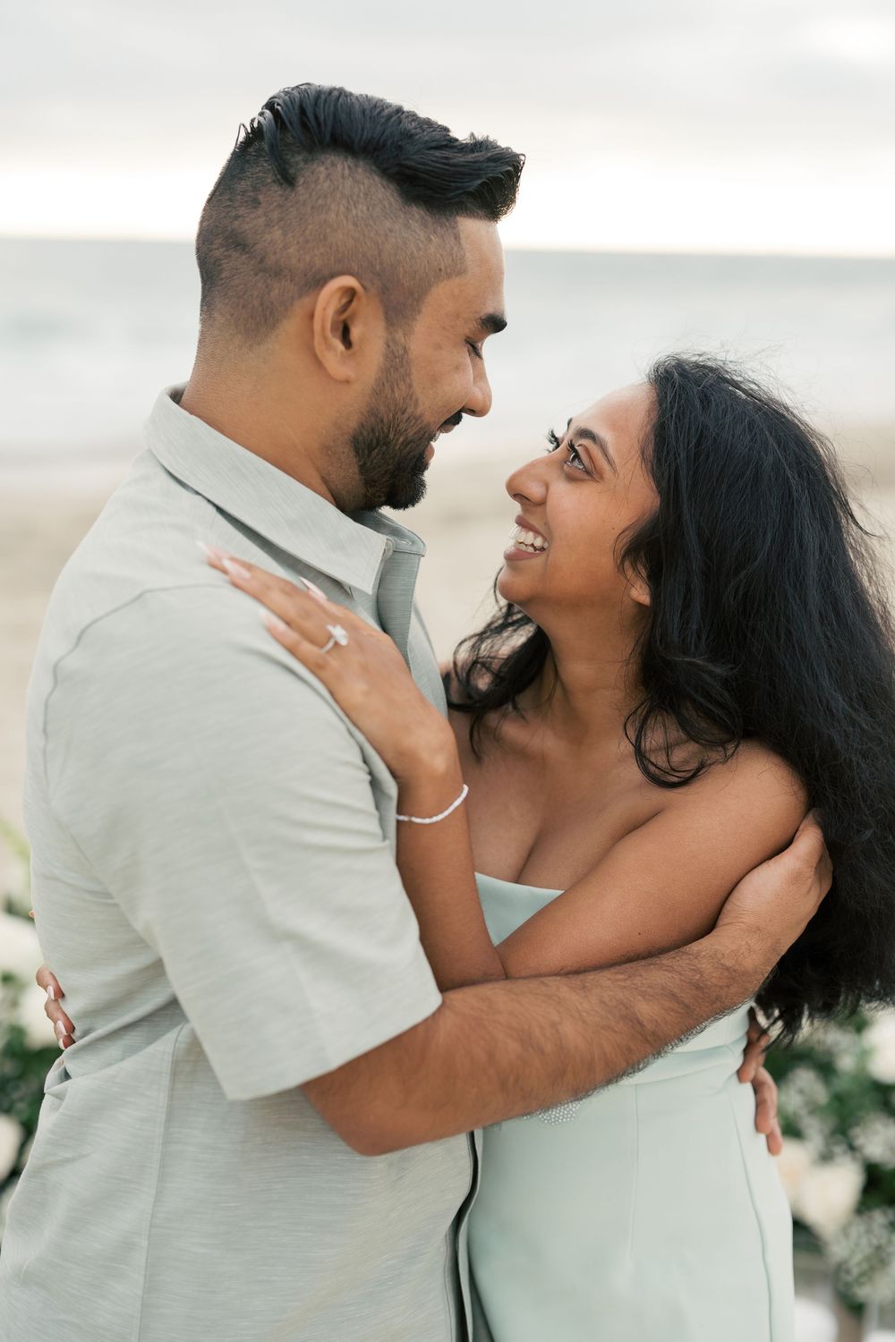 A romantic couple shares intimate embraces and laughter in a series of candid moments against a light background.