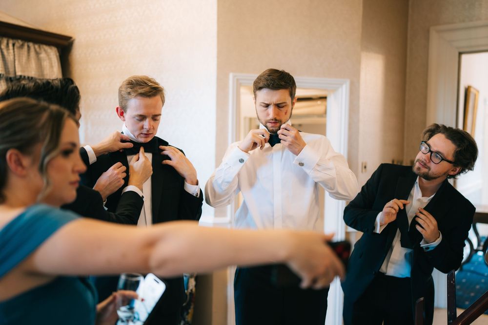 Candid moments of wedding party preparations in a bright indoor setting.