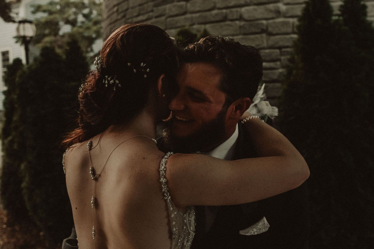 A couple shares an intimate moment during their wedding celebration in a romantic outdoor setting.