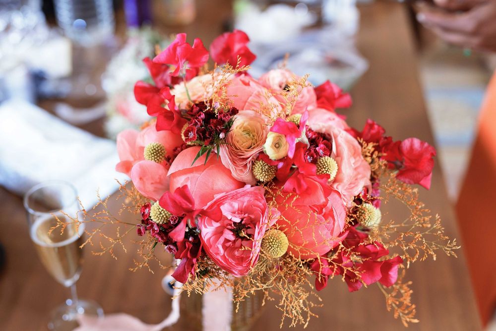 Vibrant pink and coral floral arrangement with delicate branches.