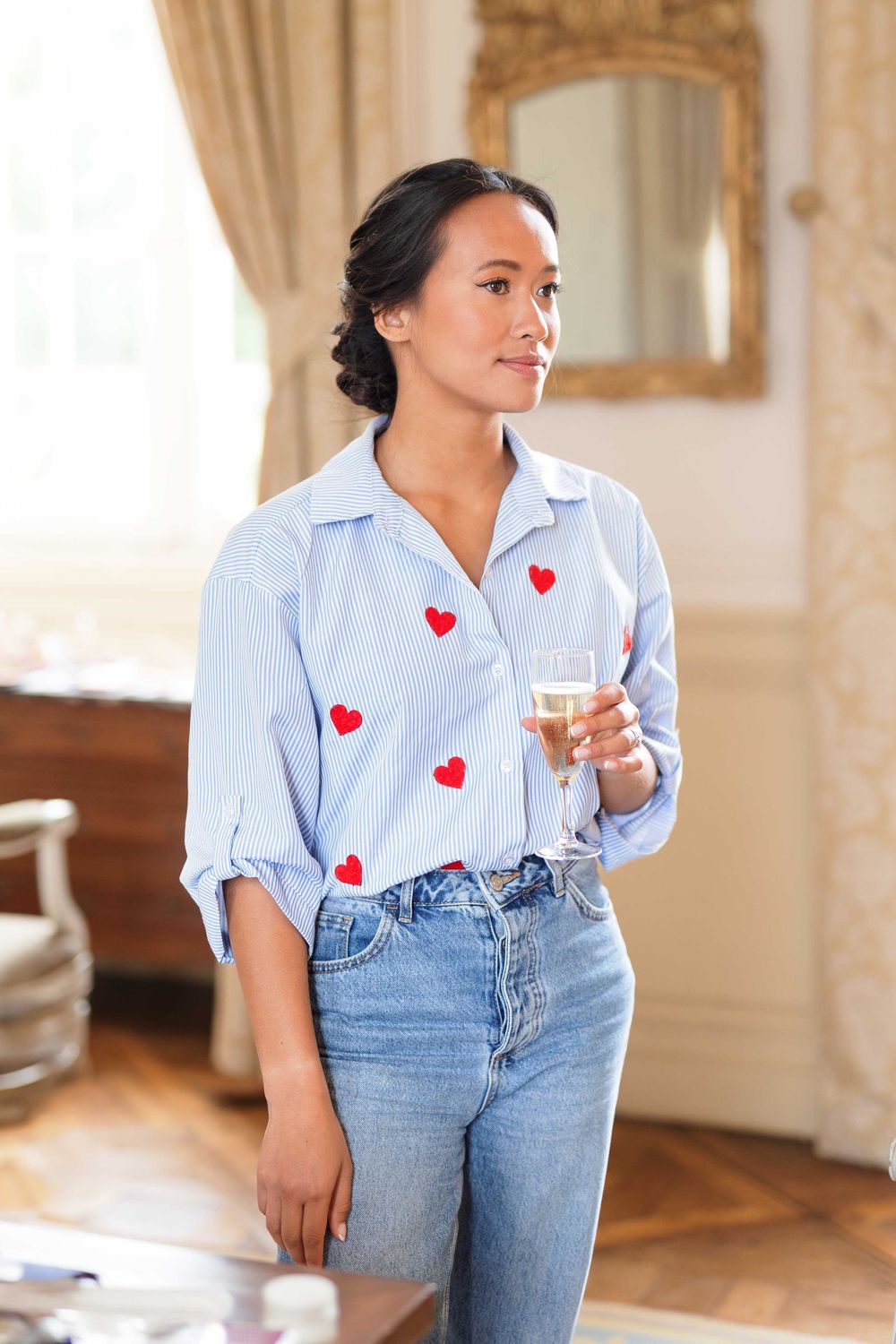 Light blue button-down shirt with heart patches paired with denim jeans.