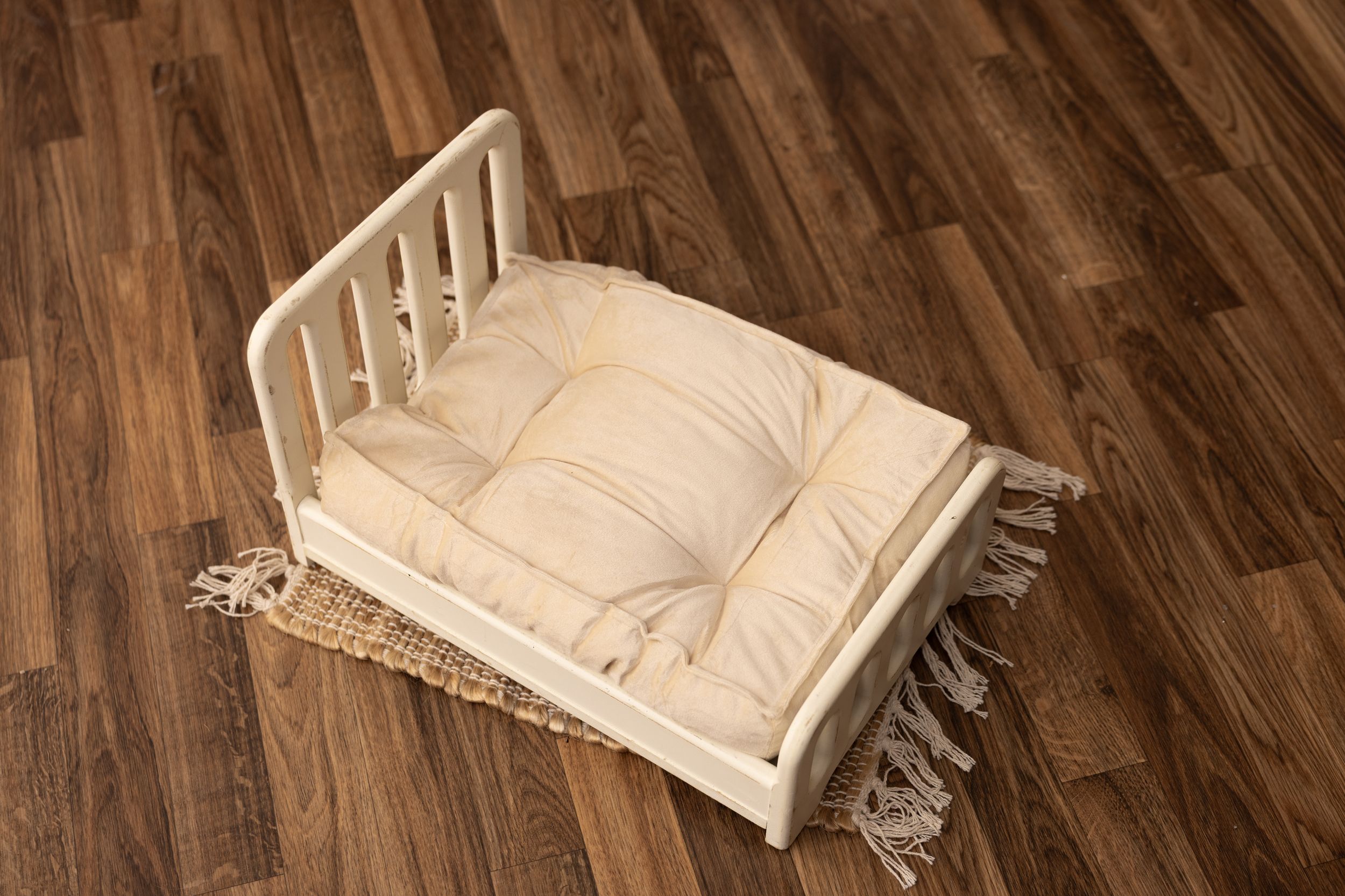 Tall slatted white newborn bed with off white mattress