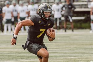 Golden West College quarterback Kauna'oa Kamakawiwo'ole runs down the sideline during a game.