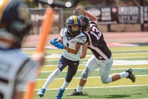 Saddleback Valley pop warner player runs past a San Clemente defender.