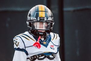 Saddleback Valley pop warner looks at the camera with his helmet on during his walk to the field before a game.