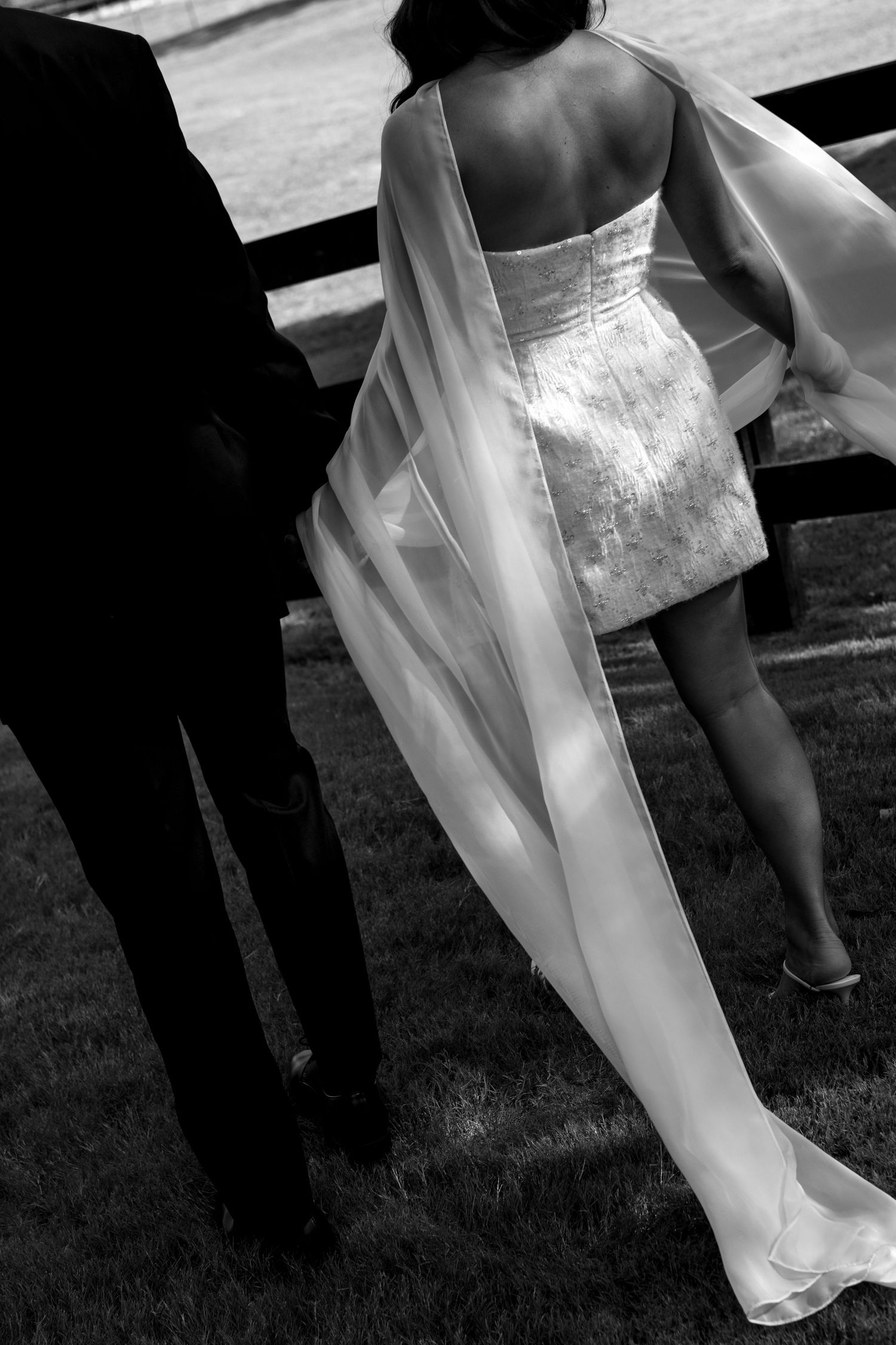 Black and white wedding photography showing flowing dress details in natural light.