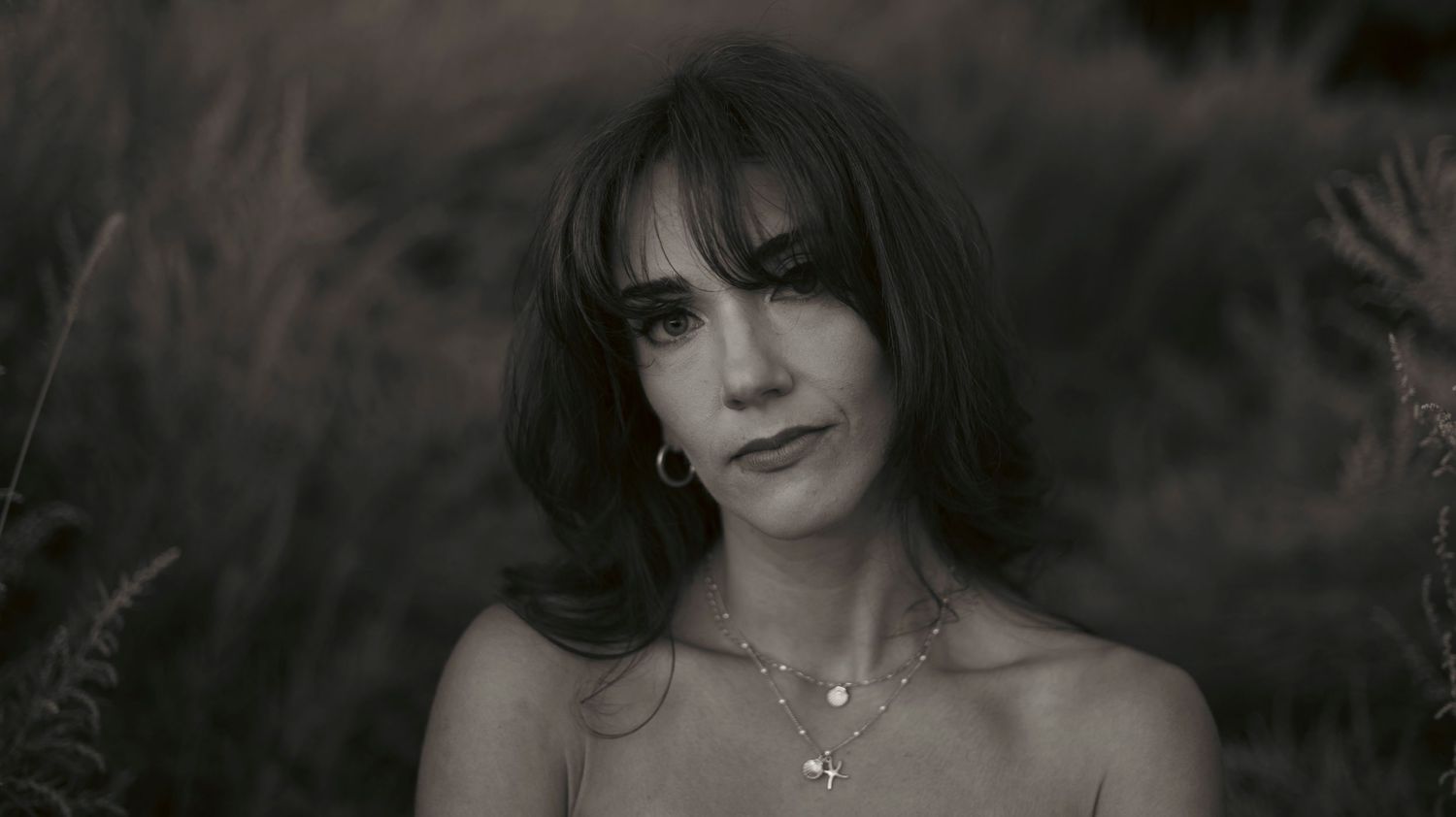 A black and white photo montage showing different poses and expressions in dramatic lighting.