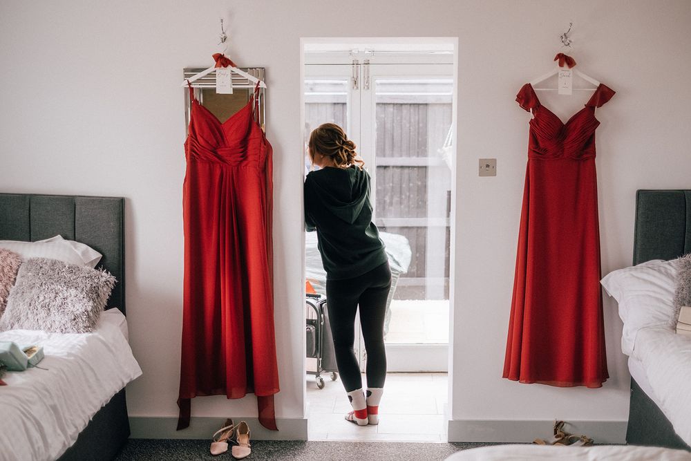 A red dress is displayed in multiple angles showing its elegant design and styling against white walls and furniture.