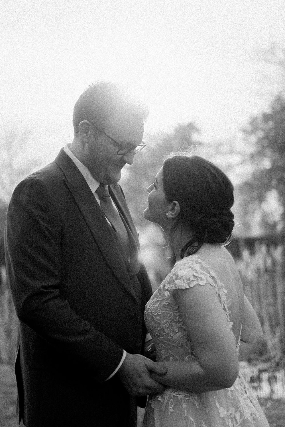 A romantic black and white wedding photo collage showing tender moments between a couple in formal attire outdoors.