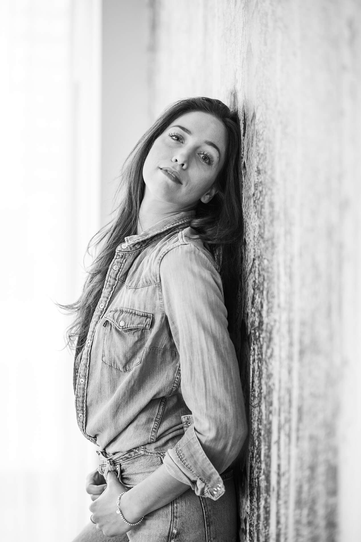 Soft monochrome portraits showing emotional expressions against textured wall.