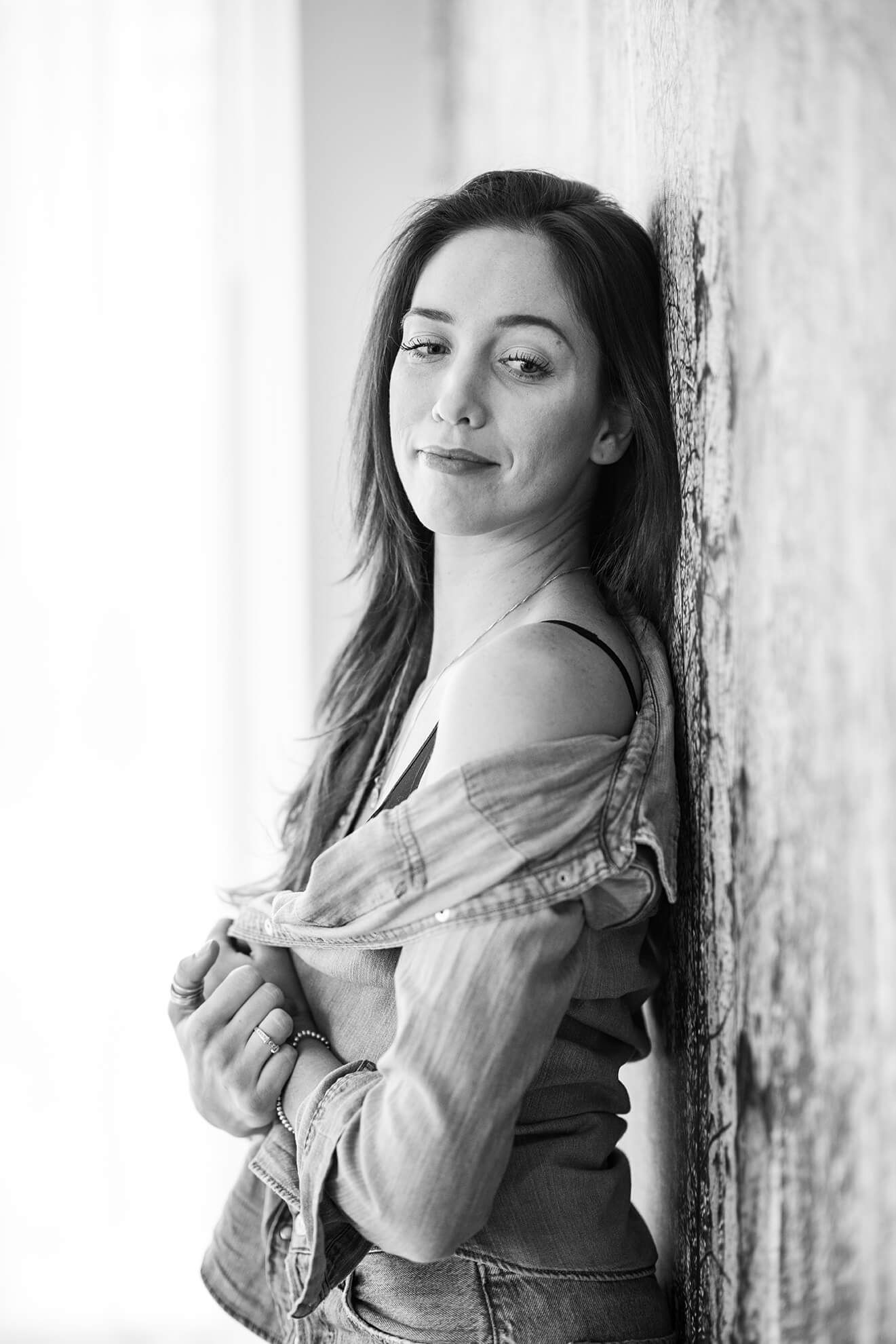 Black and white portrait series showing artistic poses against textured wall.