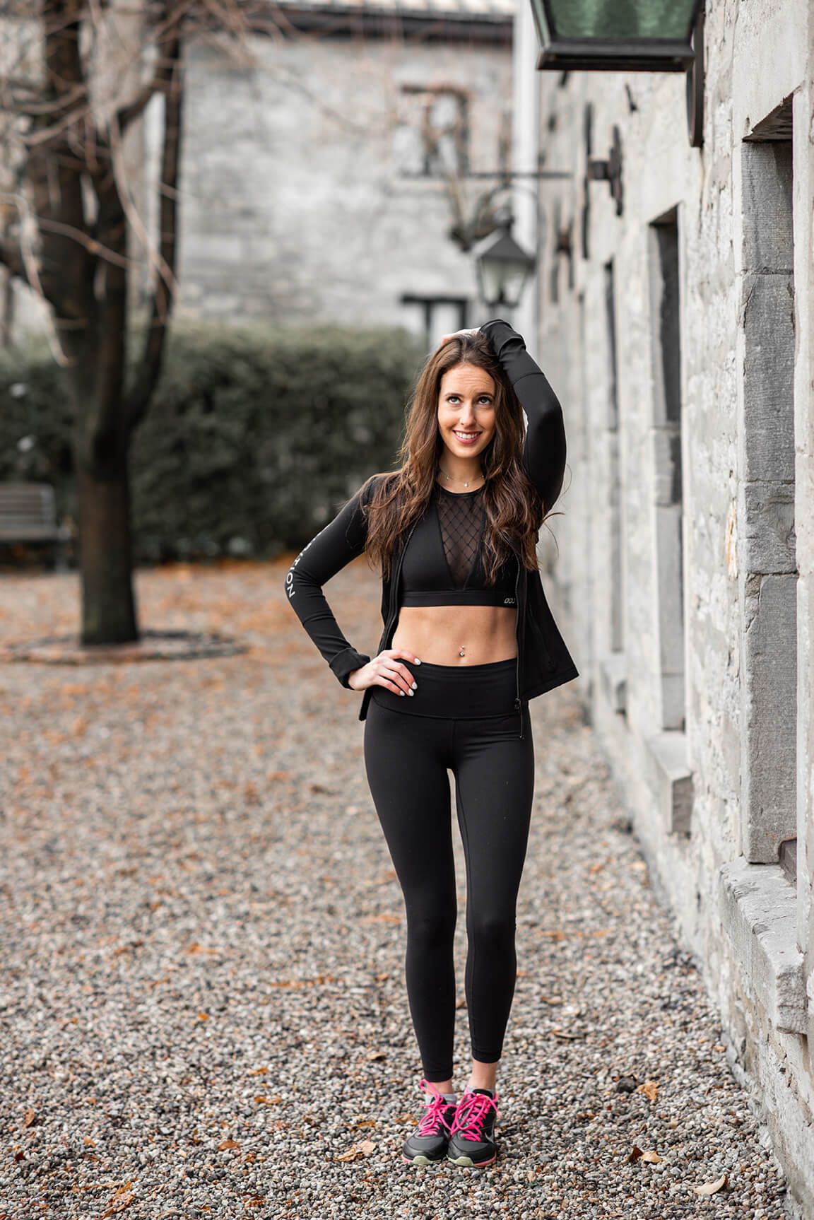 Athletic stretching demonstration along stone colonnade with autumn leaves.