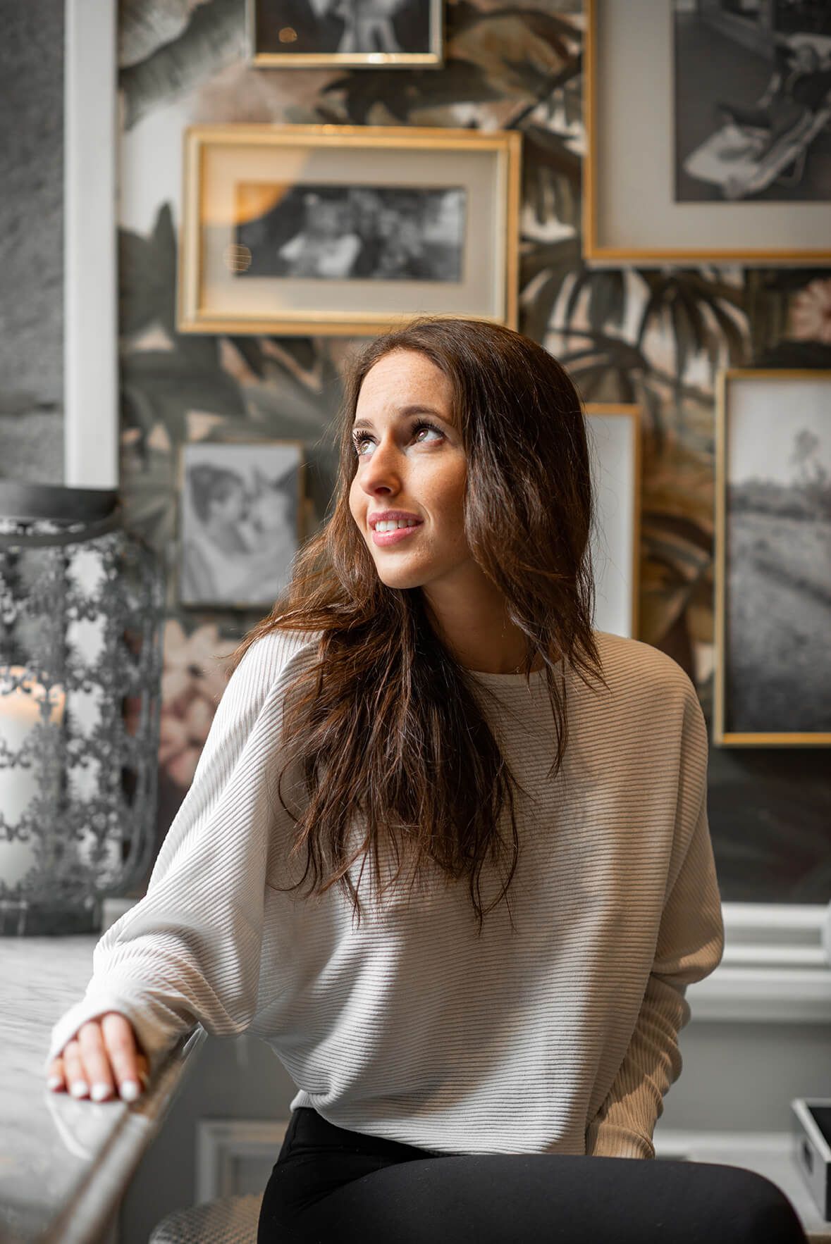 Natural light portrait session with vintage gallery wall background.